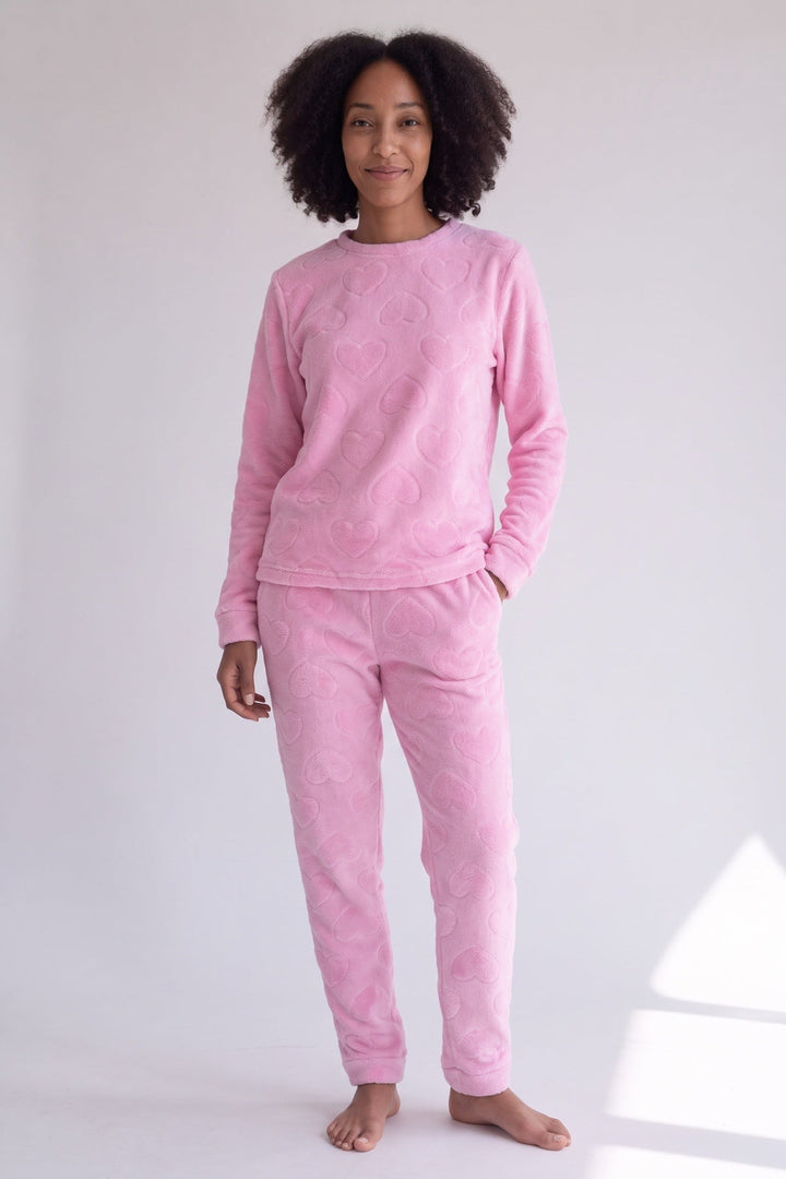 Pink teddy fleece pyjamas with embossed hearts, worn, front view