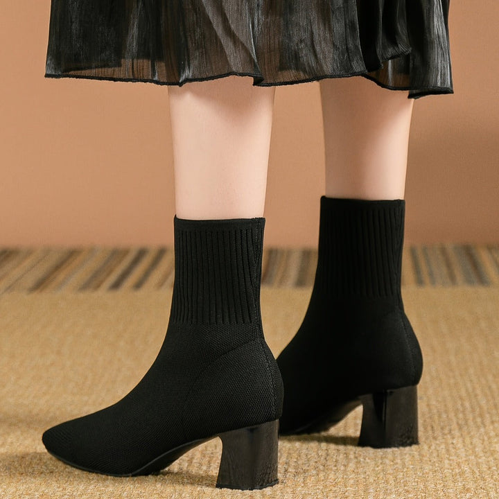 Black knit sock boots with square toe and block heel, worn
