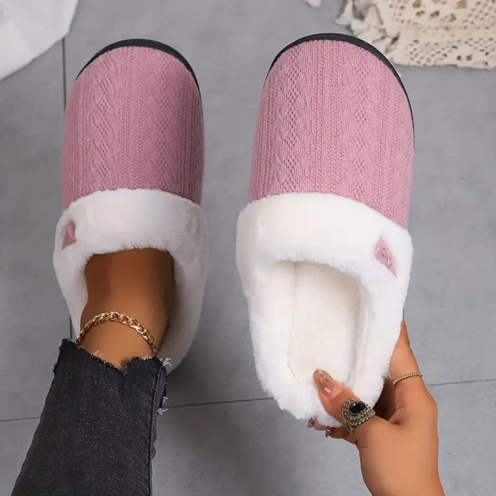 Pink knitted slippers with faux fur collar, worn