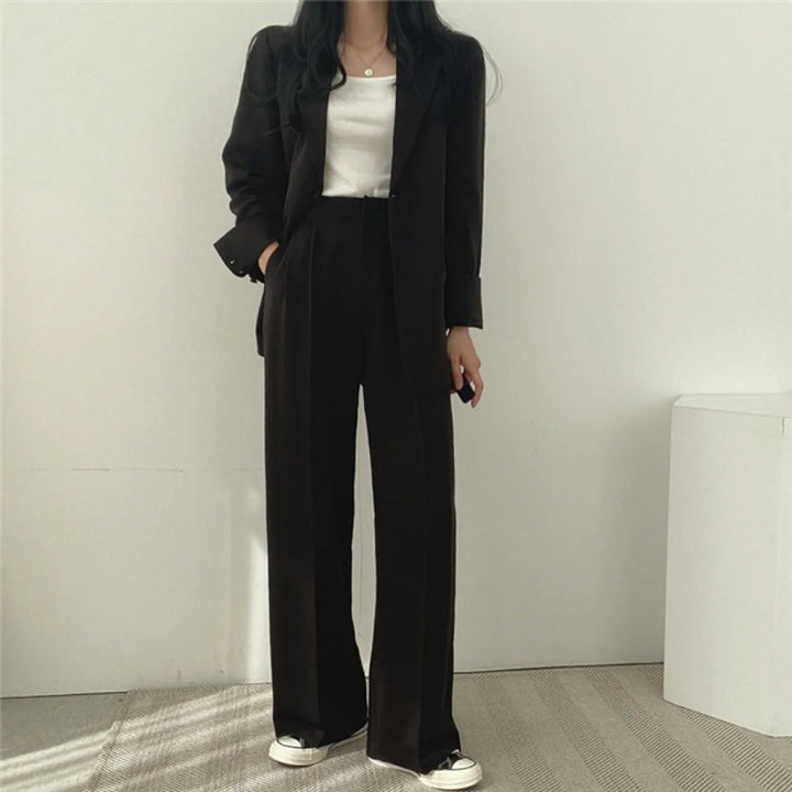 Two-piece suit with oversized blazer and wide-leg trousers in black, worn, front view
