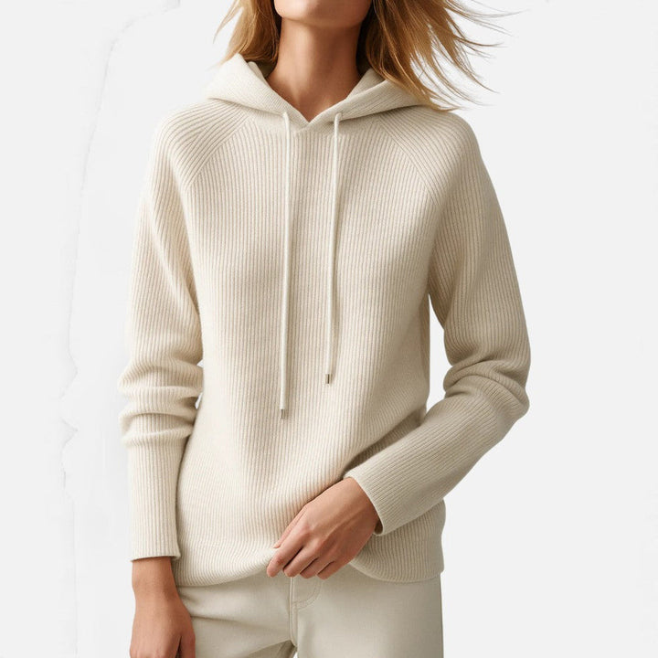 Woman wearing an off-white rib-knit hoodie with a drawcord, hands clasped in front | Grace Aura