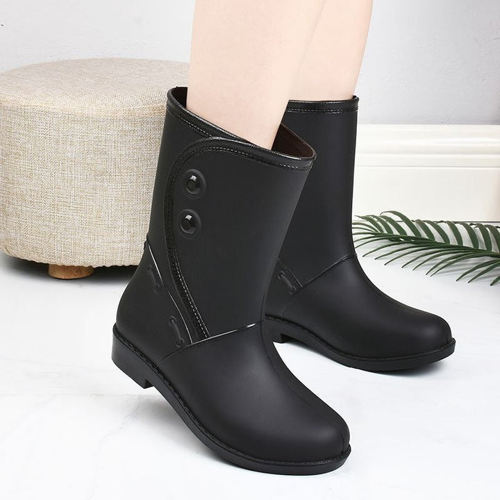 Mid-calf wellies with button detail in black, worn