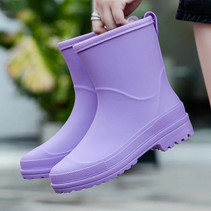 Short matte rubber wellies in lilac, held in the hand
