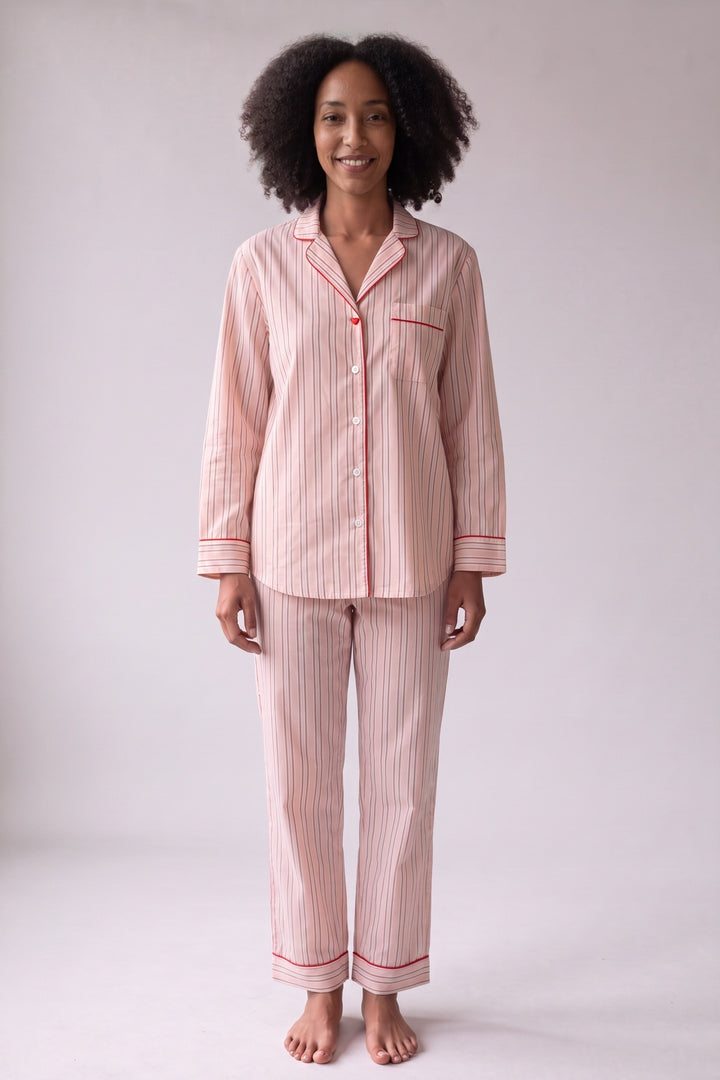 Pink striped cotton pyjamas with red piping, worn, front view