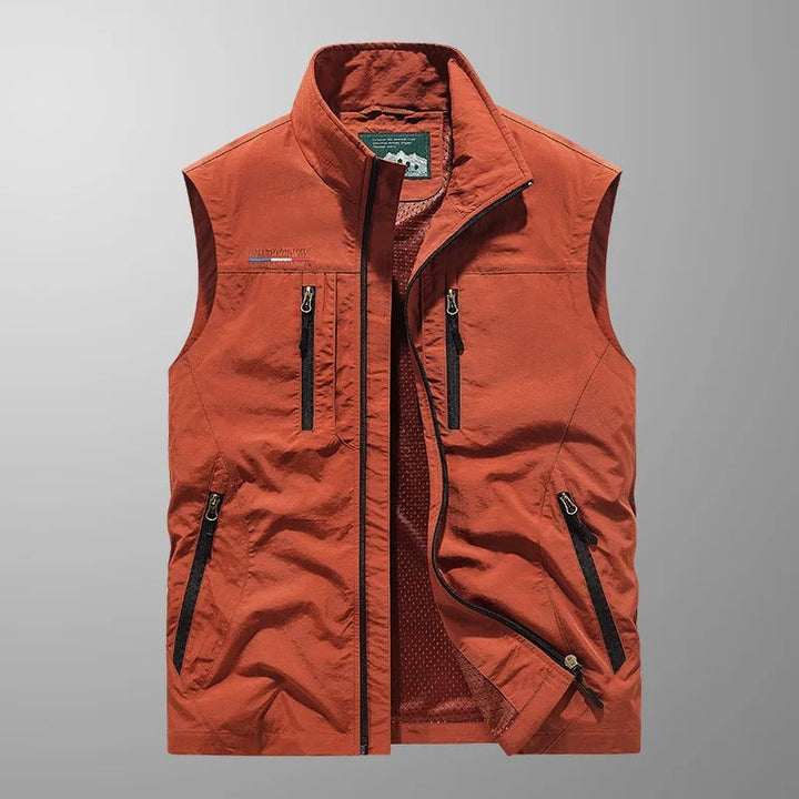 Orange sleeveless zip-up vest with multiple pockets, shown flat on background | Grace Aura
