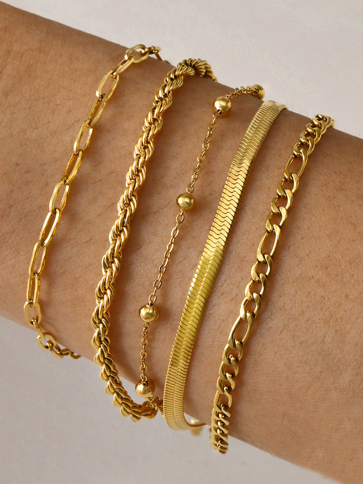 Five gold layered chain bracelets stacked on wrist, mixed link styles | Grace Aura