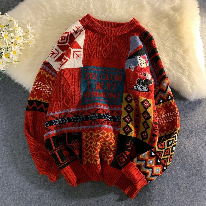 Red multicolor knitted Christmas sweater with patchwork pattern, laid flat on fabric | Grace Aura