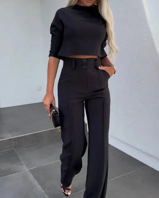Black crop top and high-waisted wide-leg trousers worn by woman | Grace Aura