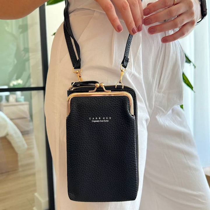Black leather crossbody phone purse with gold frame, worn by person | Grace Aura