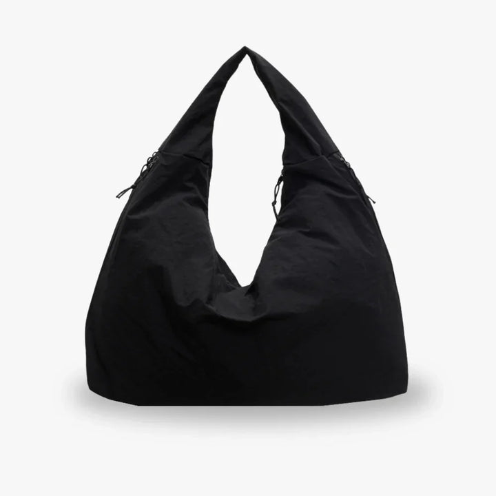 Black nylon slouchy shoulder bag with zip pocket, shown standing upright | Grace Aura
