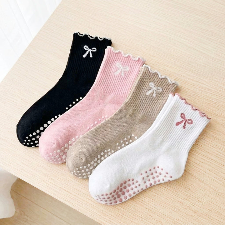 Four scalloped-cuff socks with bow embroidery, black pink beige white, laid flat | Grace Aura
