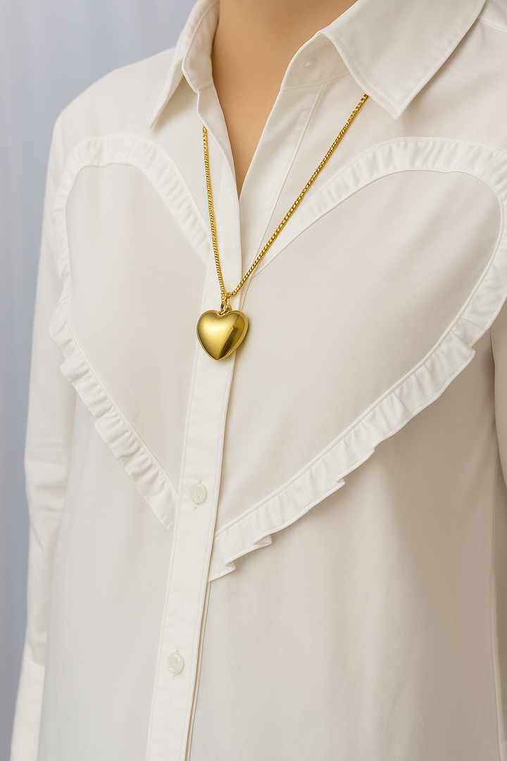 Gold heart pendant necklace worn over white ruffled blouse | Grace Aura