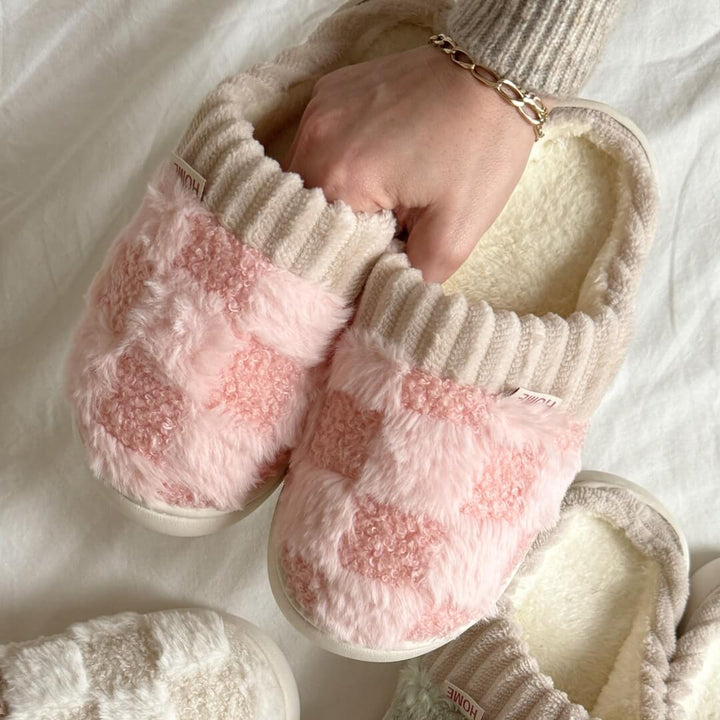 Pink checkered fuzzy slipper with cream knit collar, worn on hand | Grace Aura