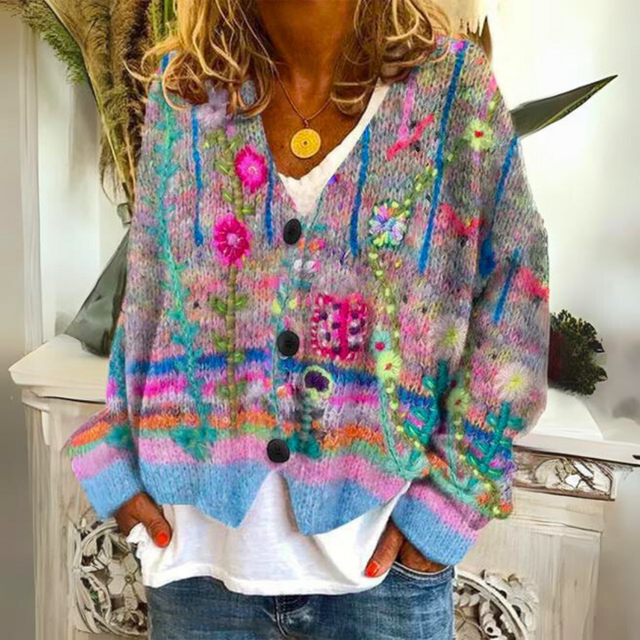Woman wearing colorful floral knitted button-up cardigan over white top and jeans | Grace Aura