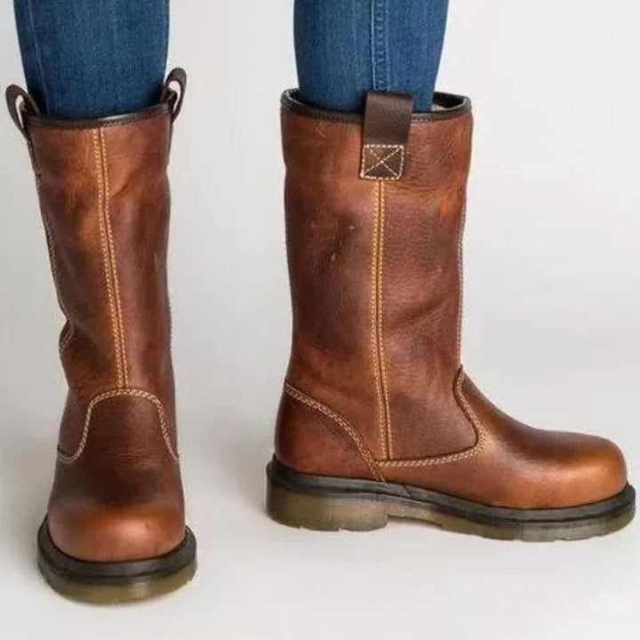 Brown leather pull-on boots with pull tab, worn by person, side view | Grace Aura