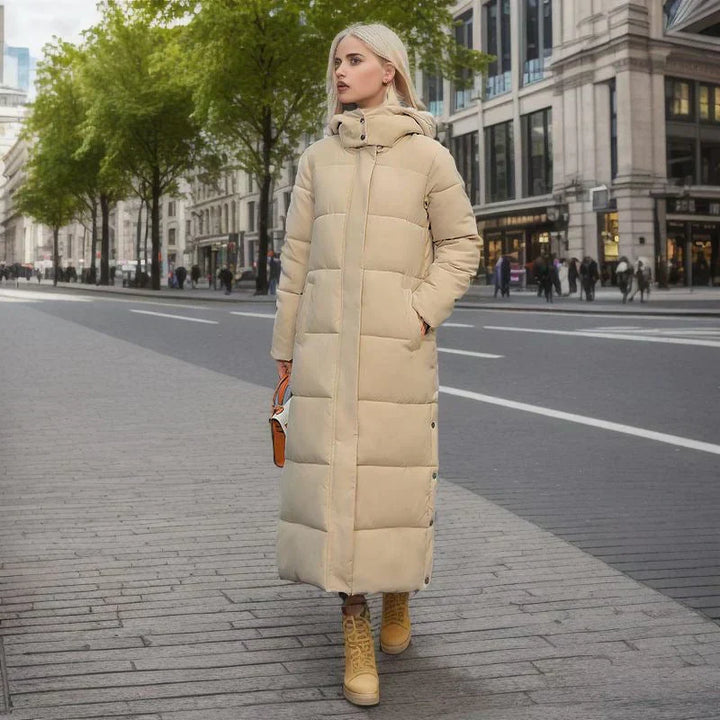 Woman wearing beige quilted long puffer jacket with hood on street | Grace Aura