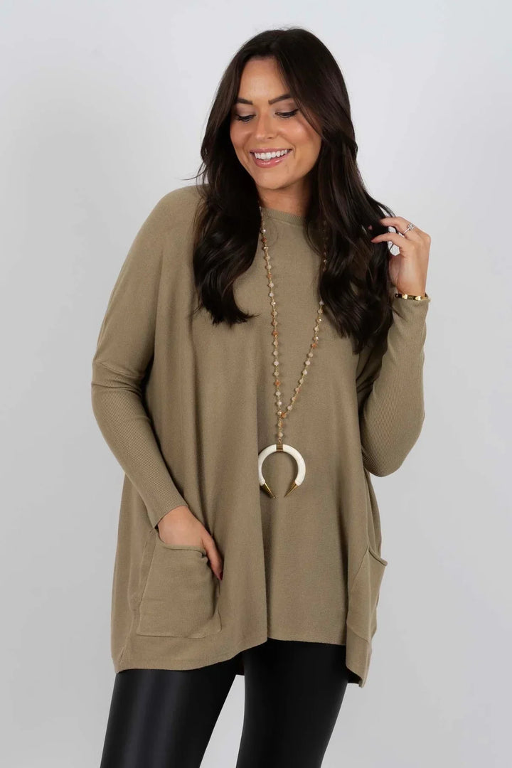 Woman wearing olive green oversized sweater with front pockets and horn necklace | Grace Aura
