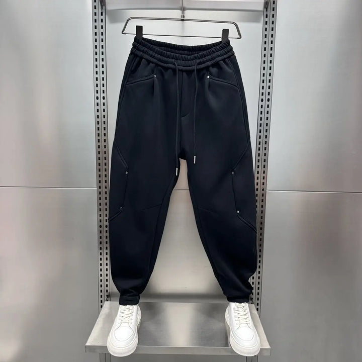 Black baggy joggers with elastic waist, hung on display rack | Grace Aura