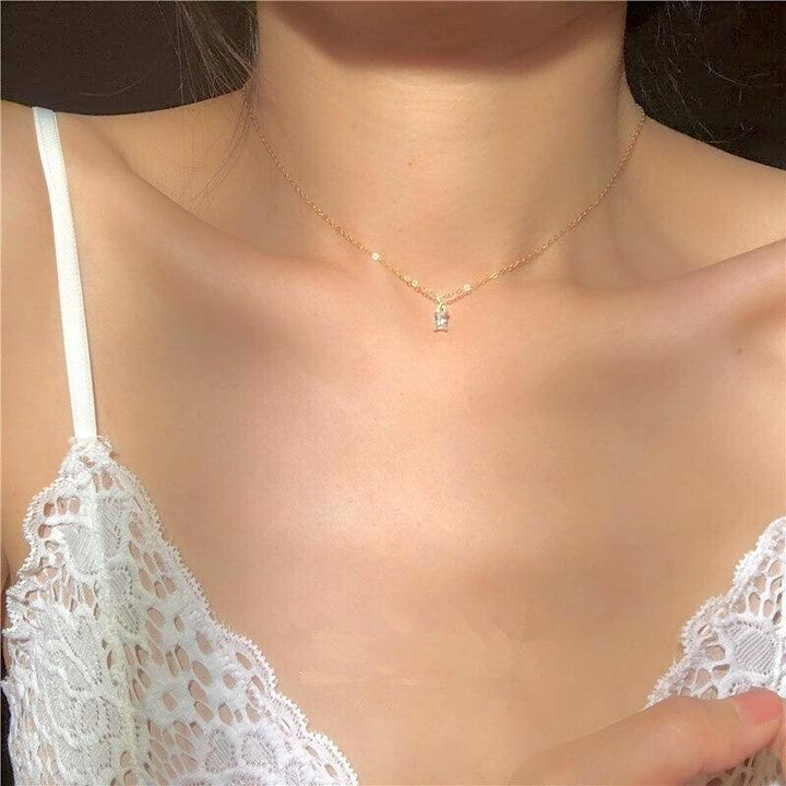 Gold chain necklace with small clear pendant worn by woman | Grace Aura