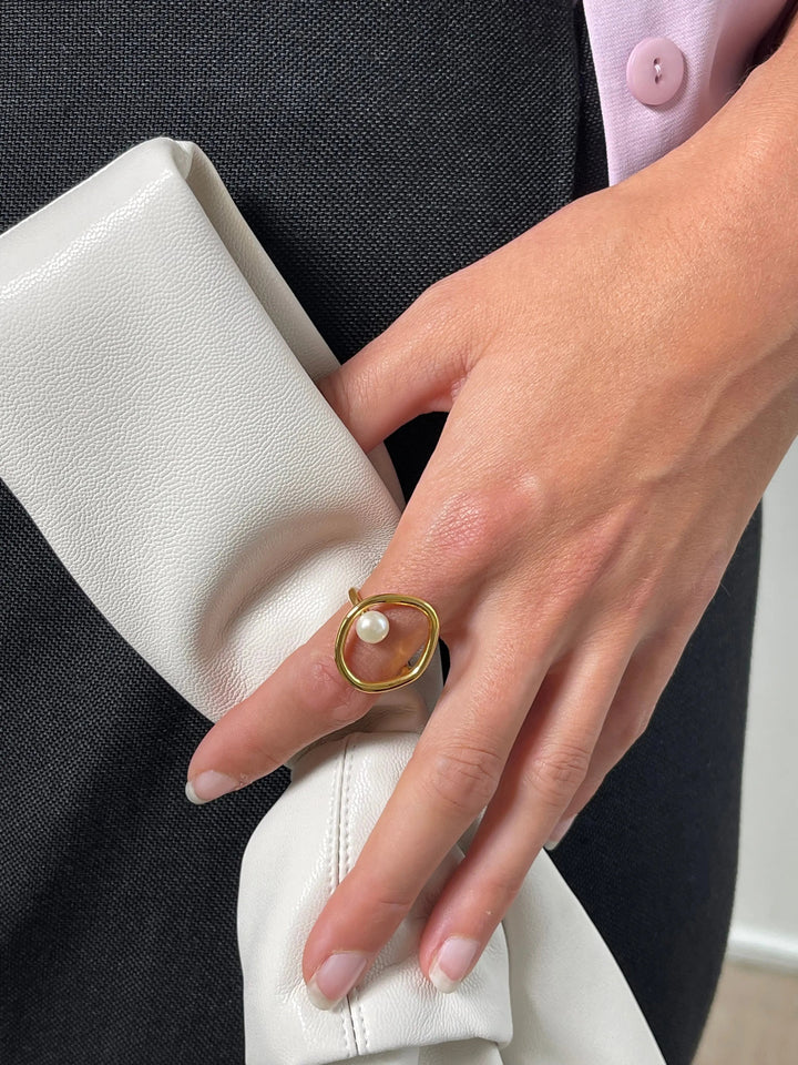 Gold oval ring with pearl accent worn on hand model | Grace Aura