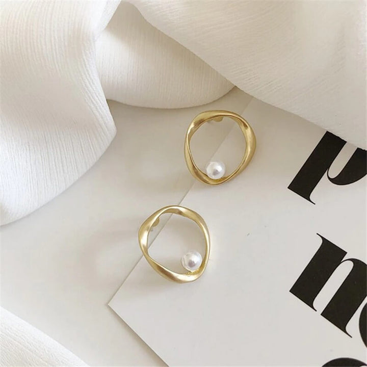 Matte gold irregular hoop earrings with pearl accents, flat lay display | Grace Aura
