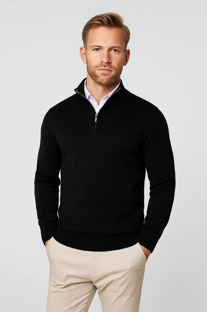 Man wearing black knitted quarter-zip jumper with white shirt and beige trousers | Grace Aura