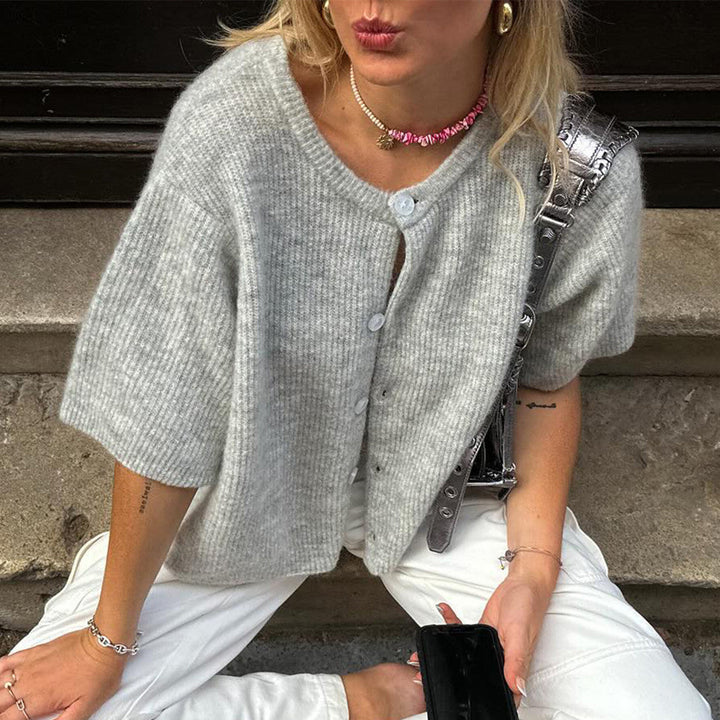 Gray ribbed knit button-up cardigan, short sleeves, worn by seated woman | Grace Aura