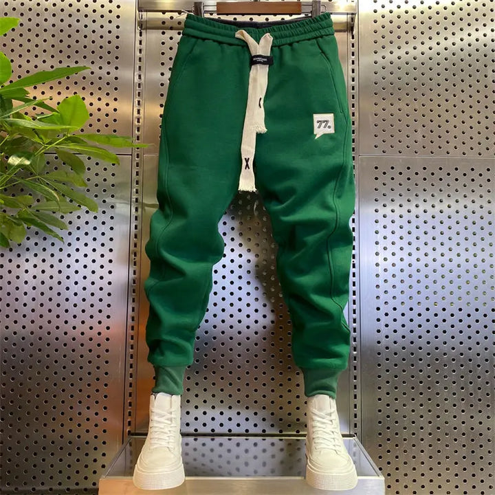 Green fleece jogger sweatpants with drawstring waist, displayed with white sneakers | Grace Aura