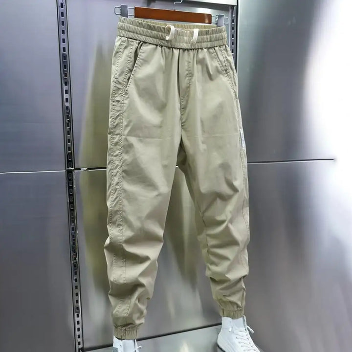 Beige cotton cargo joggers with elastic waist, worn on hanger display | Grace Aura