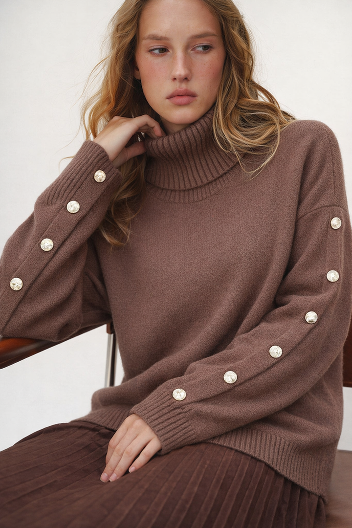 Brown knitted turtleneck sweater with pearl button sleeve details, worn by model | Grace Aura