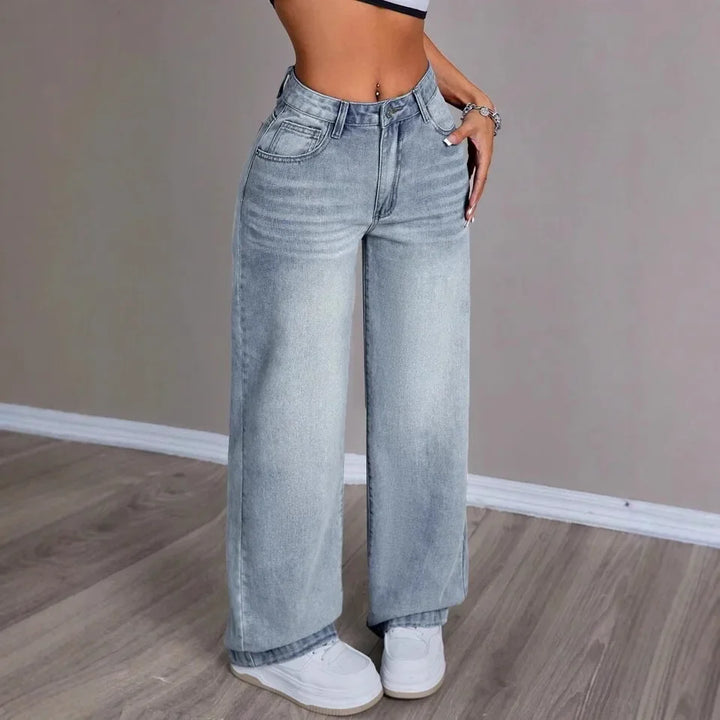 Light blue wide-leg high-waist denim jeans worn by woman standing indoors | Grace Aura
