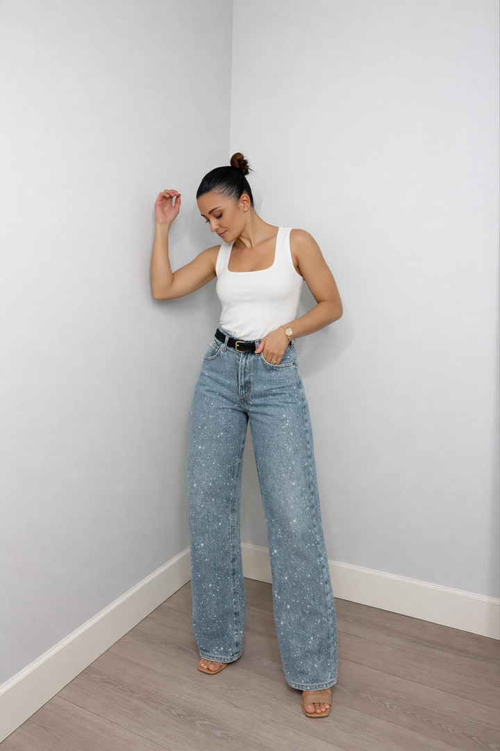 Woman wearing white tank top and light blue wide-leg denim jeans with belt | Grace Aura