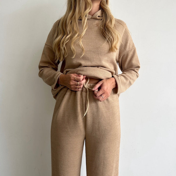 Woman wearing beige ribbed hoodie and matching wide leg drawstring trousers | Grace Aura