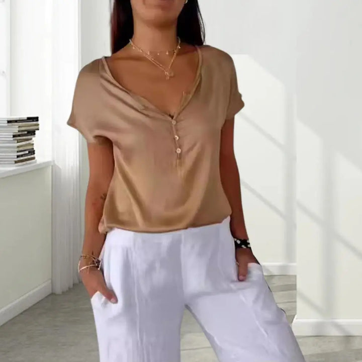 Woman wearing tan satin V-neck button T-shirt with white trousers | Grace Aura