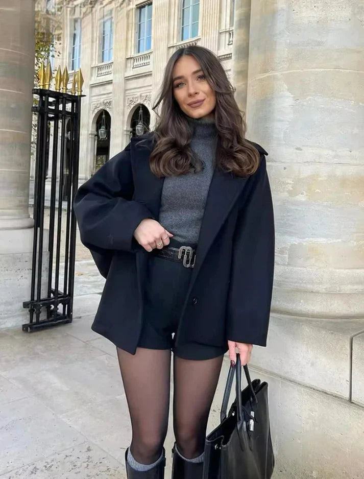 Woman wearing black oversized wool jacket with belted shorts outdoors | Grace Aura