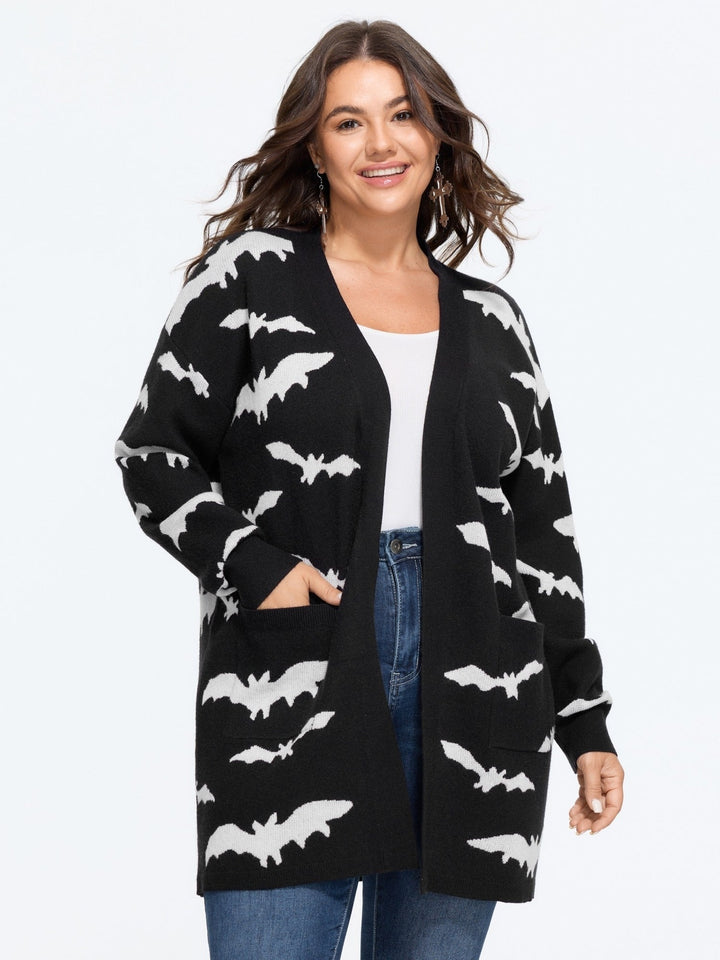 Woman in the long black bat cardigan over a white top