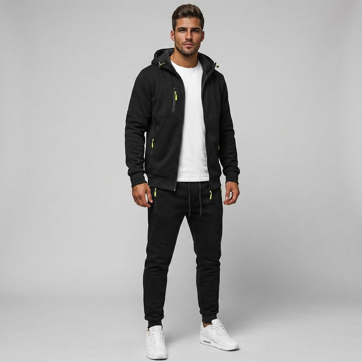 Man wearing black zip hoodie and matching joggers with white sneakers | Grace Aura