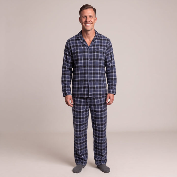Man wearing navy plaid flannel pyjama set with grey socks, standing | Grace Aura