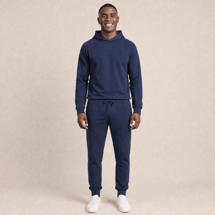 Man wearing navy raglan hoodie and matching jogger sweatpants, smiling | Grace Aura