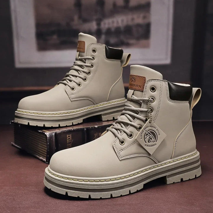 Beige leather lace-up work boots with chunky sole, displayed on books | Grace Aura