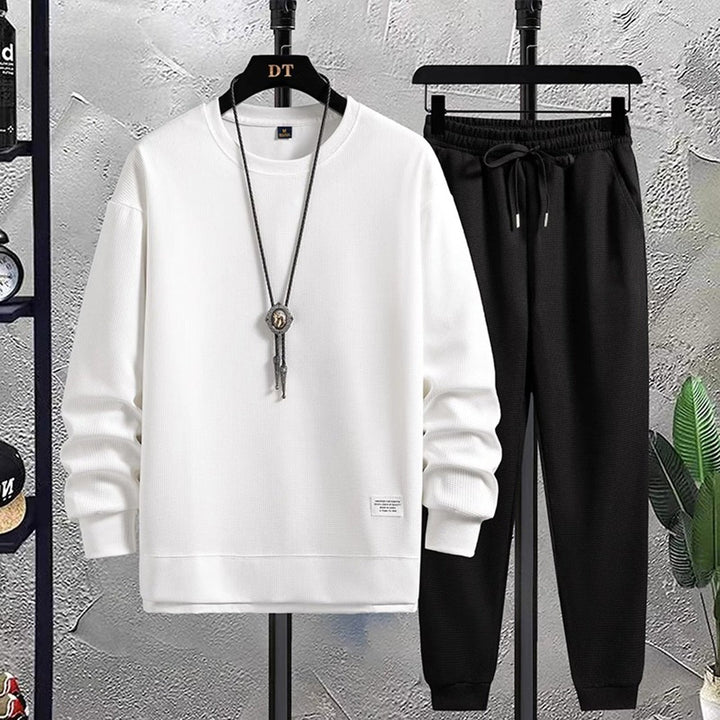 White waffle-texture sweatshirt and black joggers on hangers