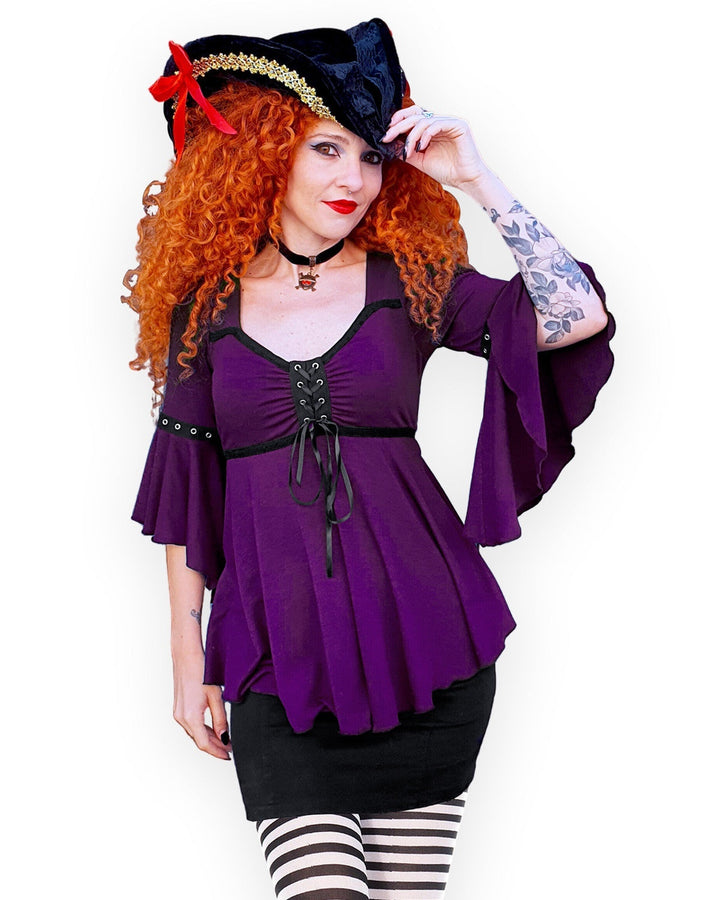 Woman in the plum pirate costume with the black pirate hat and striped tights