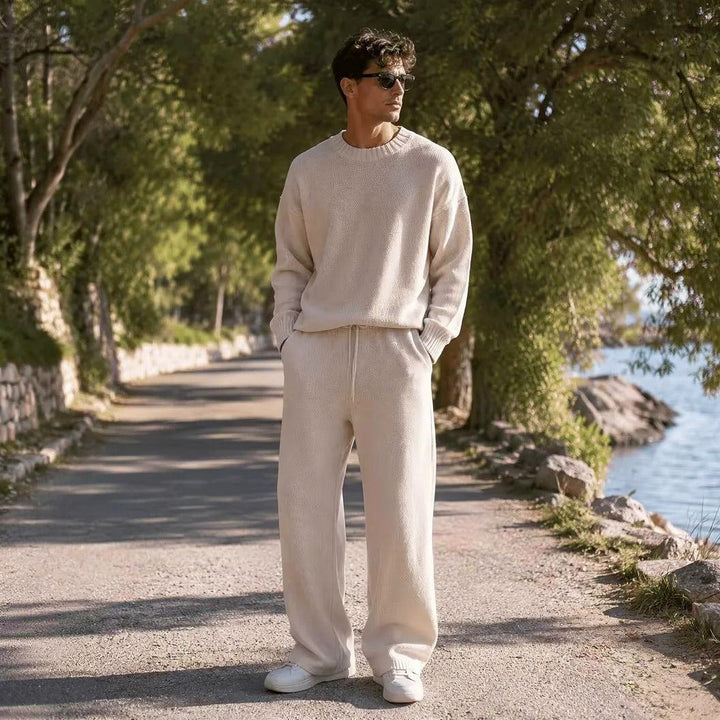 Man wearing cream oversized knit jumper and wide trousers outdoors | Grace Aura
