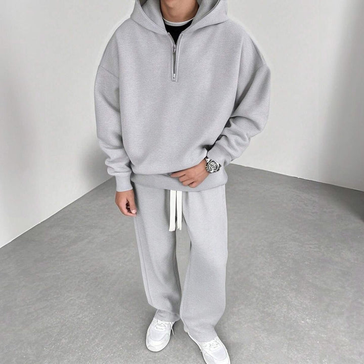 Man wearing grey half-zip hoodie and matching wide-leg joggers, worn outfit | Grace Aura