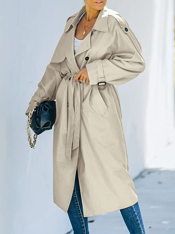 Khaki long double-breasted trench coat with belt, worn with jeans