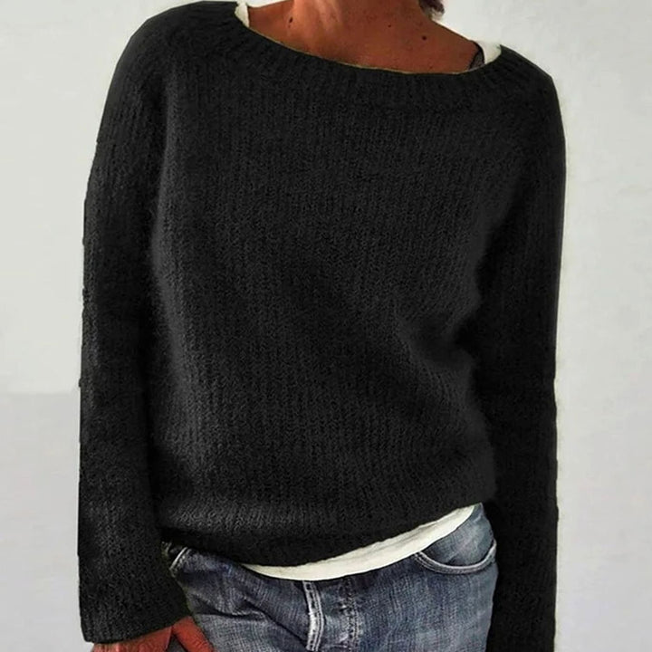 Black knit oversized sweater worn by woman, layered over white top with jeans | Grace Aura