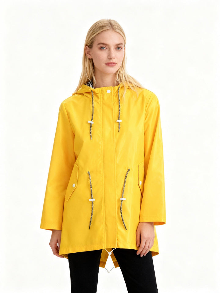 Woman in a yellow water-repellent rain jacket with hood and drawstrings