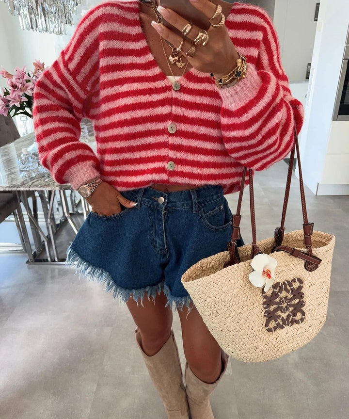 Red-and-pink striped oversized cardigan worn with denim shorts