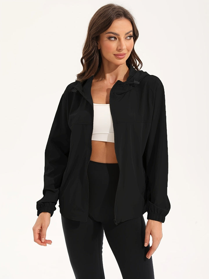 Black lightweight hooded windbreaker worn open over a white sports top