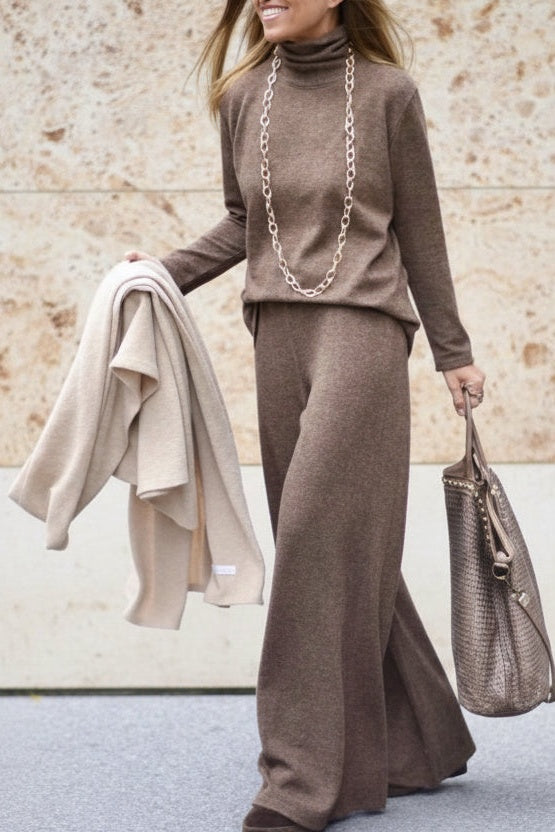 Brown fine-knit co-ord set with a roll-neck jumper and wide-leg trousers, worn walking, front view